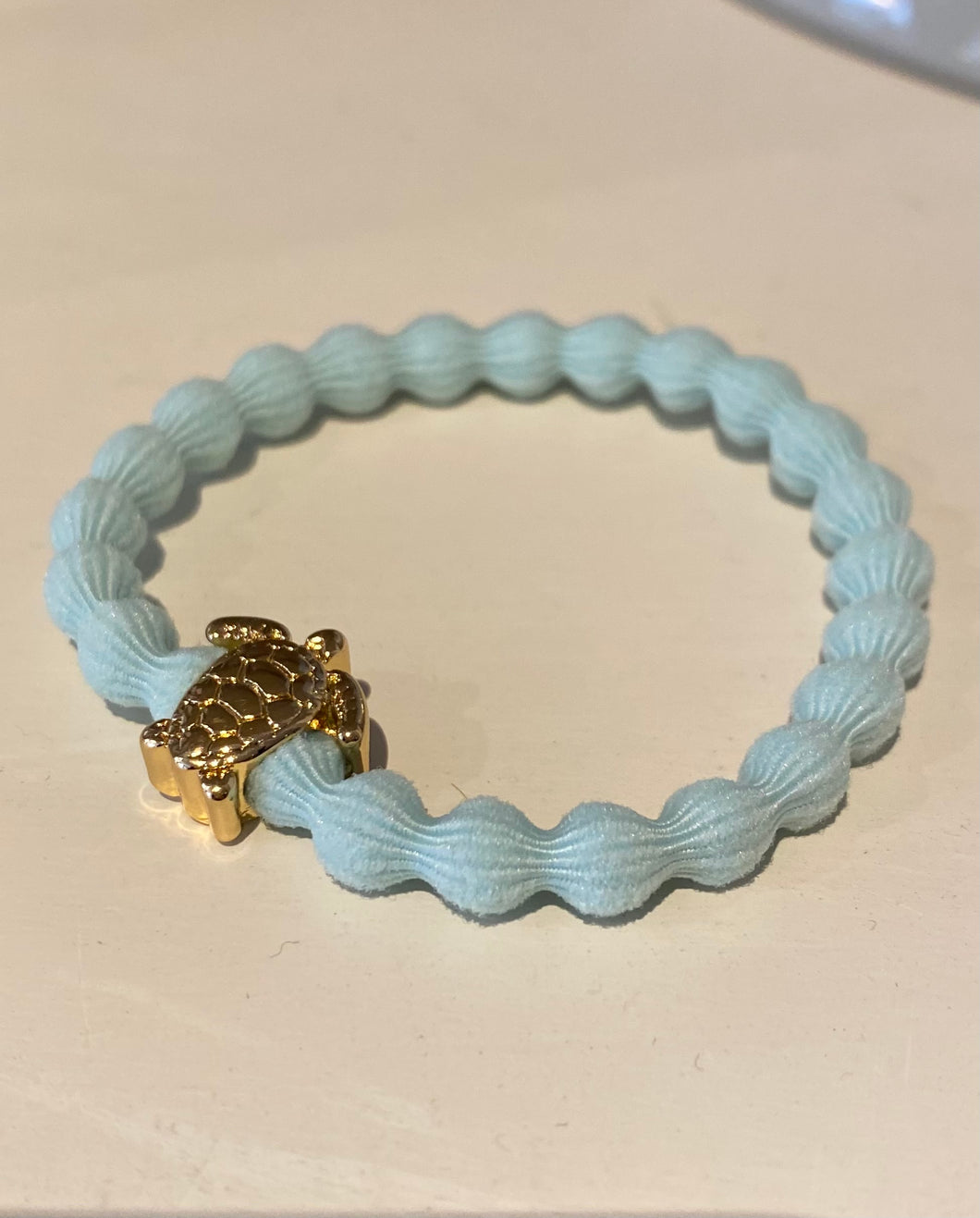 Aqua bracelet with a silver/gold turtle 